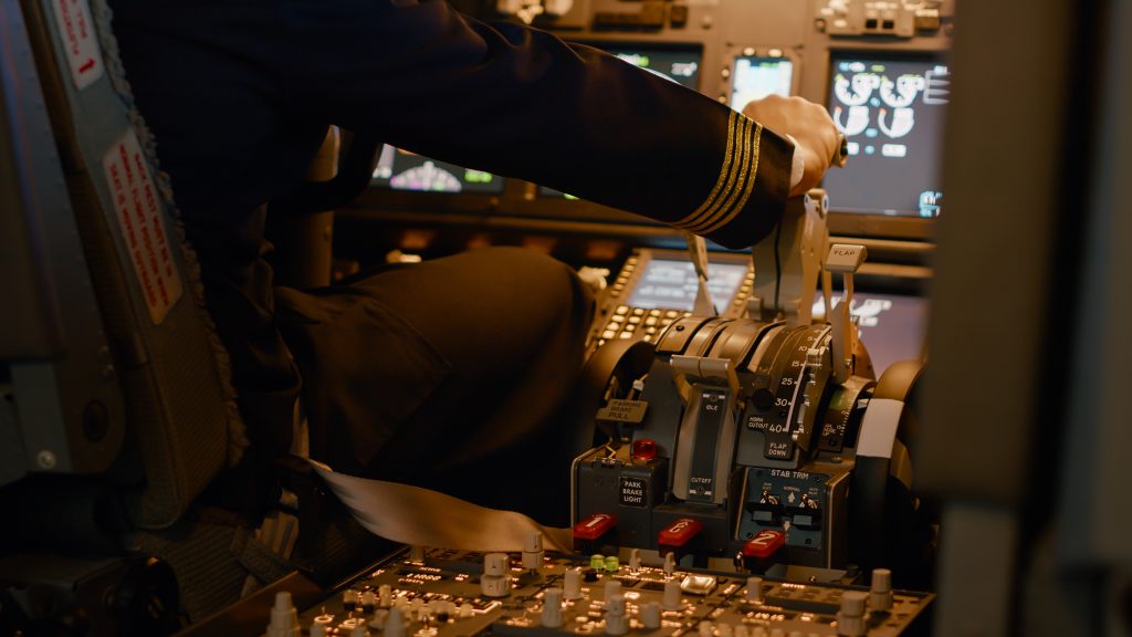 Pilot in einem abgedunkelten Cockpit betätigt den Starthebel