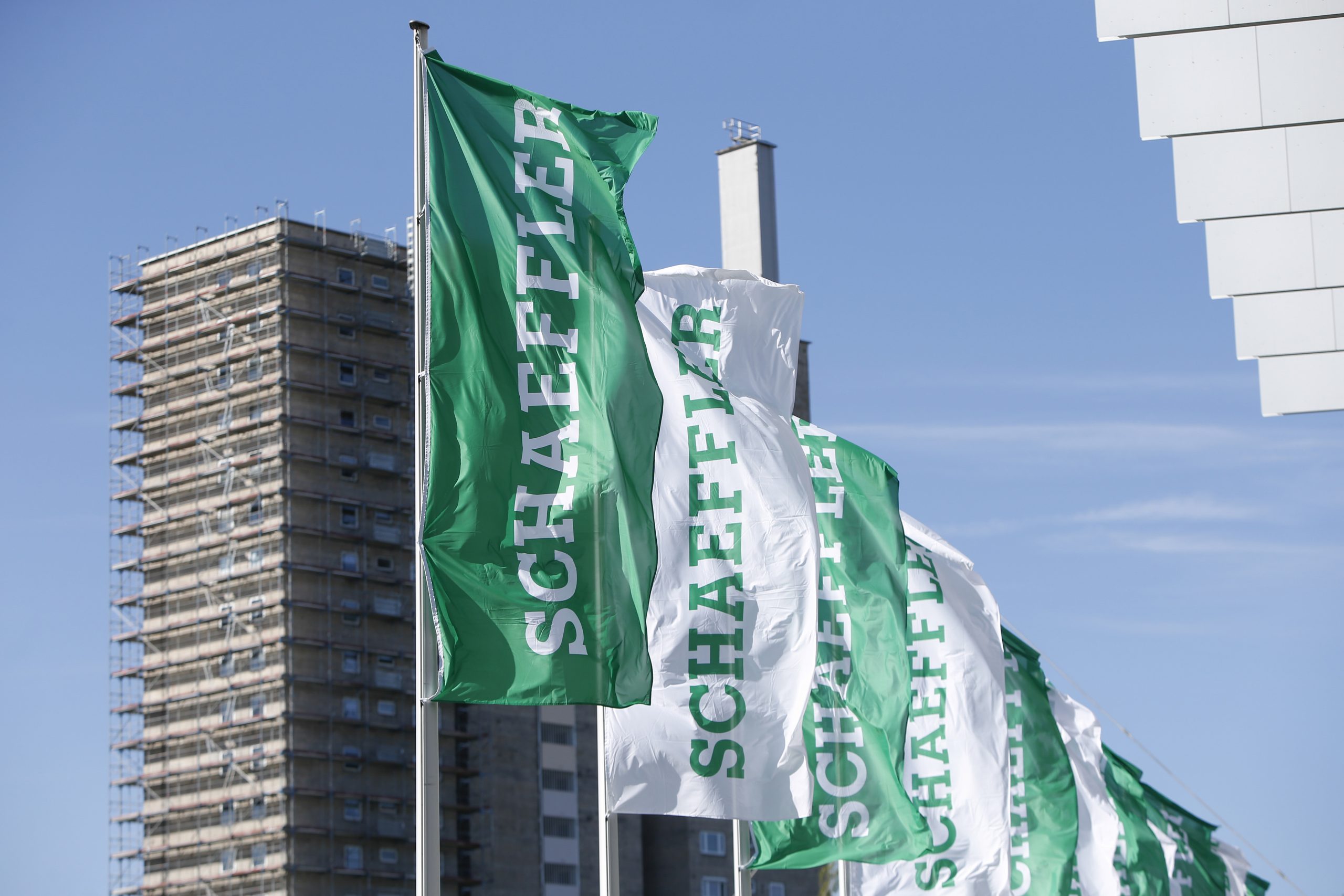 Grüne Flaggen der Firma Schaeffler vor dem Firmengebäude