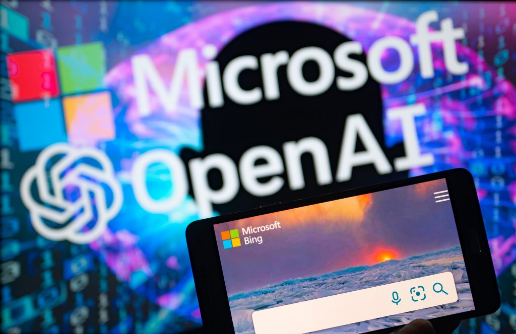 Logo von Microsoft und OpenAI sowie Suchmaschine Bing am Handy