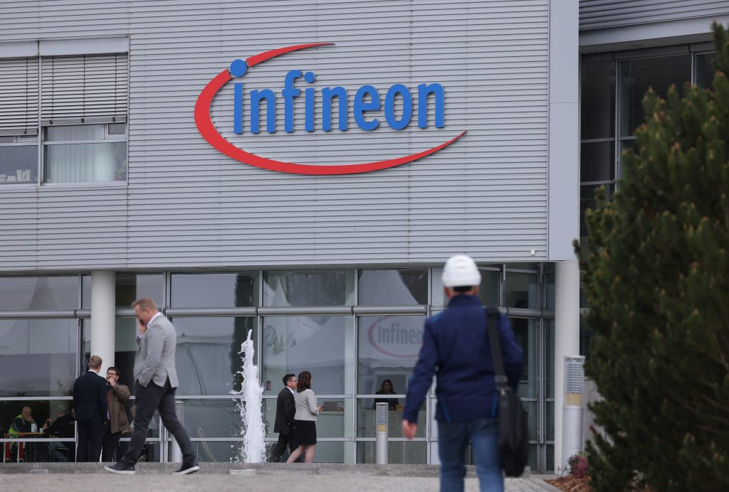Firmengebäude von Infineon und ein paar Menschen vor dem Eingang