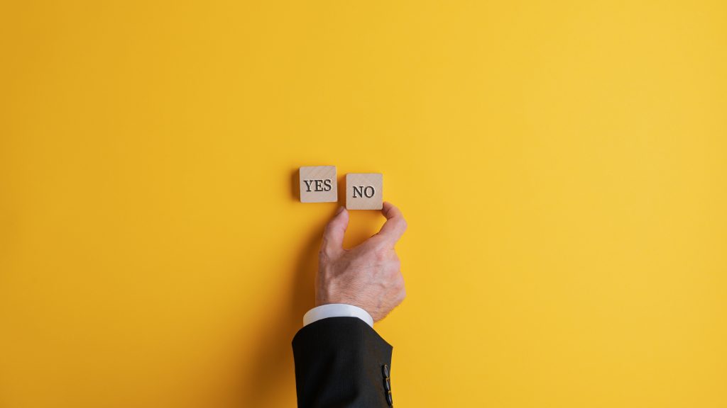 Gelber Hintergrund auf dem yes und no in Buchstaben von einer Hand gelegt wird
