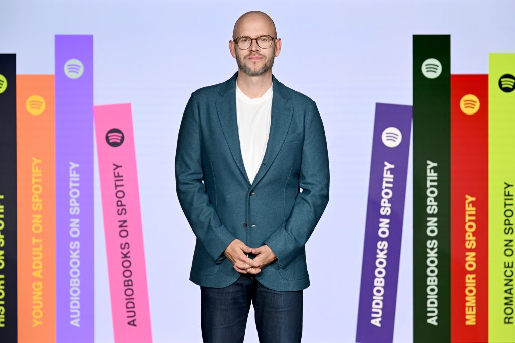 Daniel Ek als CEO von Spotify steht neben bunten Streifen von Spotify